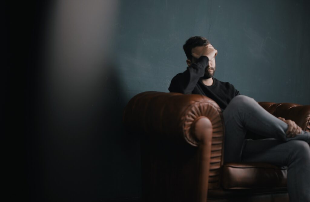 Man sitting on couch depressed